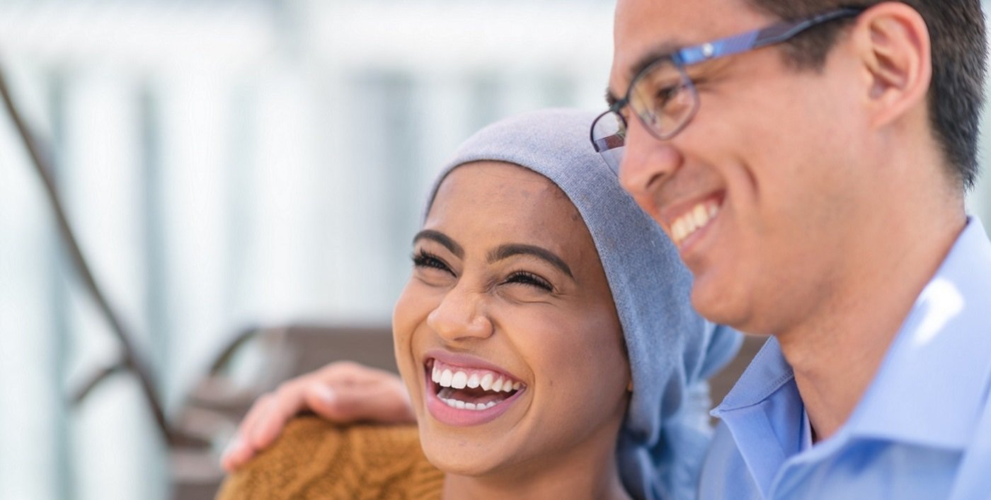 Cancer patient smiling with supportive companion during treatment